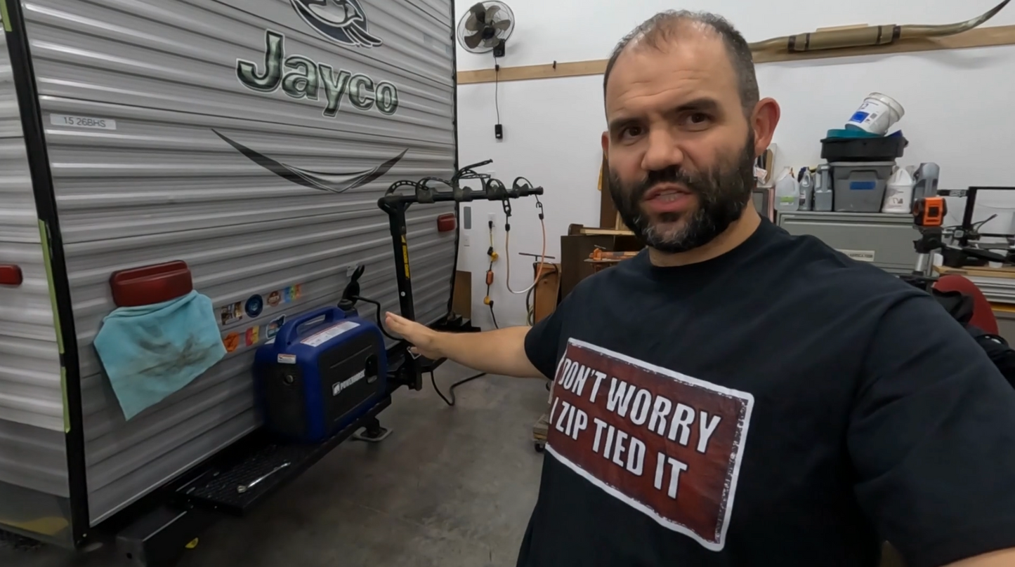 Custom welded steel RV rear bumper rack holding a generator, gas can, and bikes, built by Creative Enterprises LLC. (I promise I didn't actually zip tie it ;)