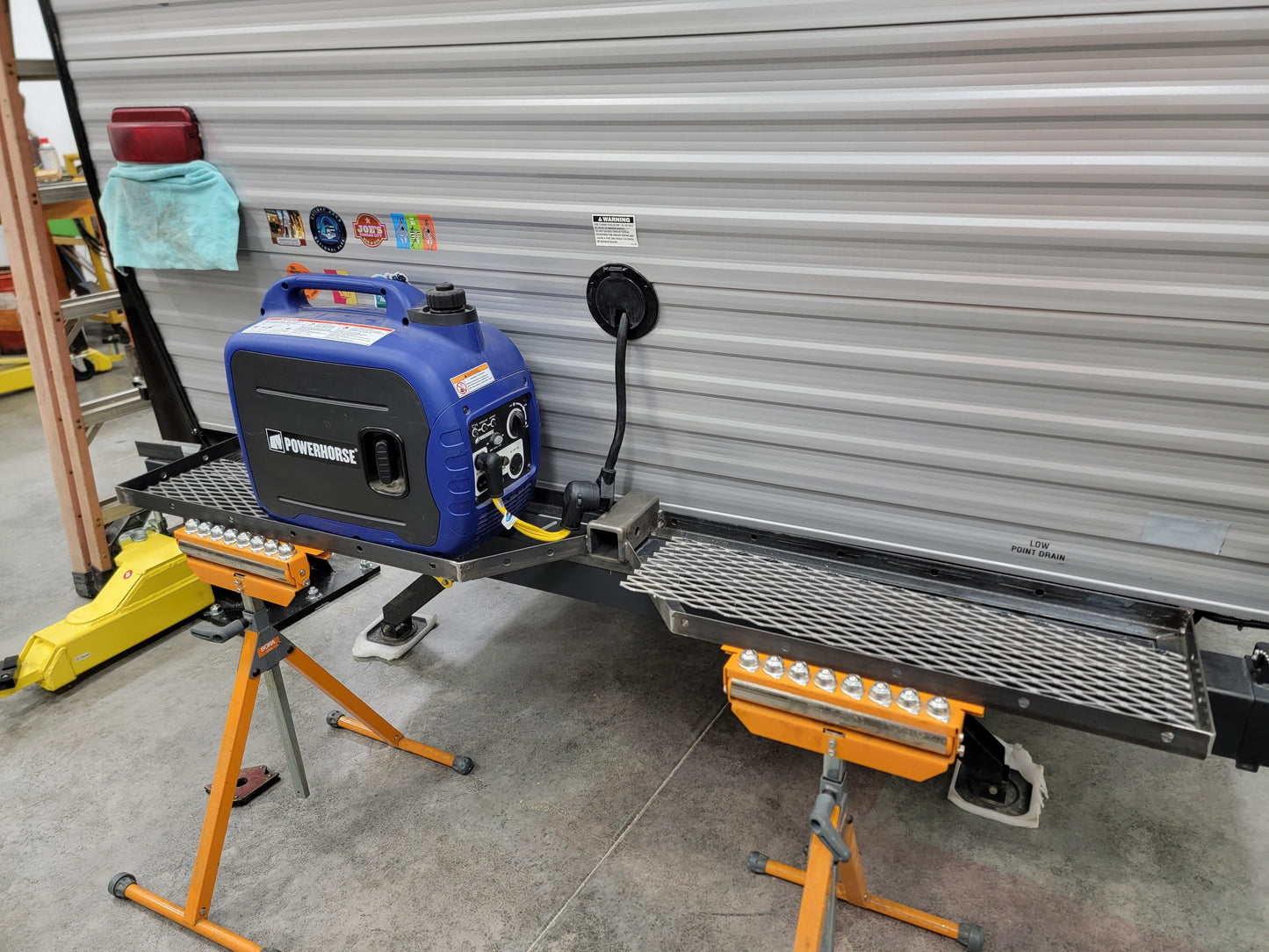 Portable generator on custom RV rear bumper rack with receiver hitch bike mount.