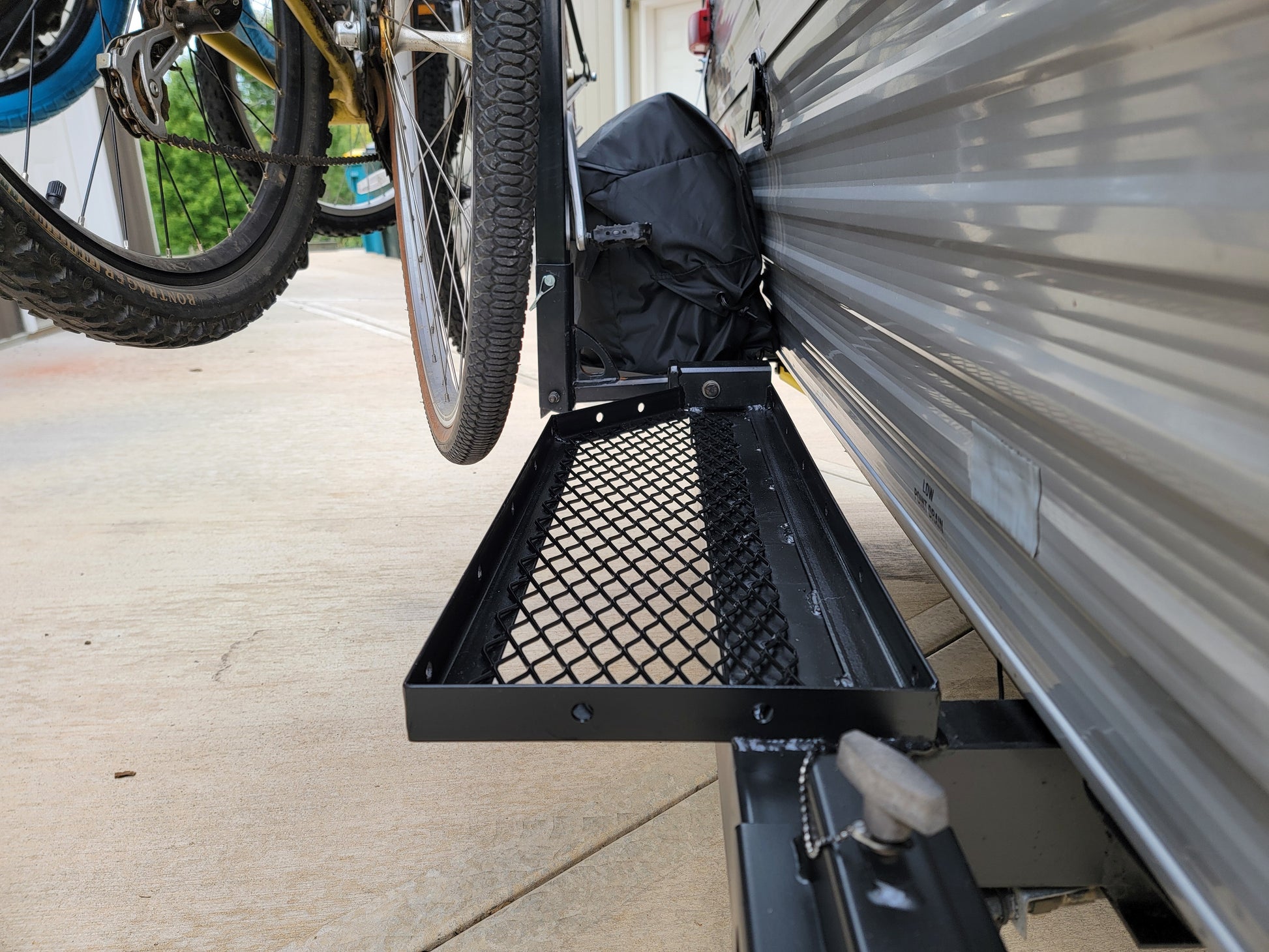 Bicycle rack on rear of RV trailer with a generator and storage platform.
