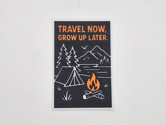 Black, orange, and gray Travel Now Grow Up Later camping magnet