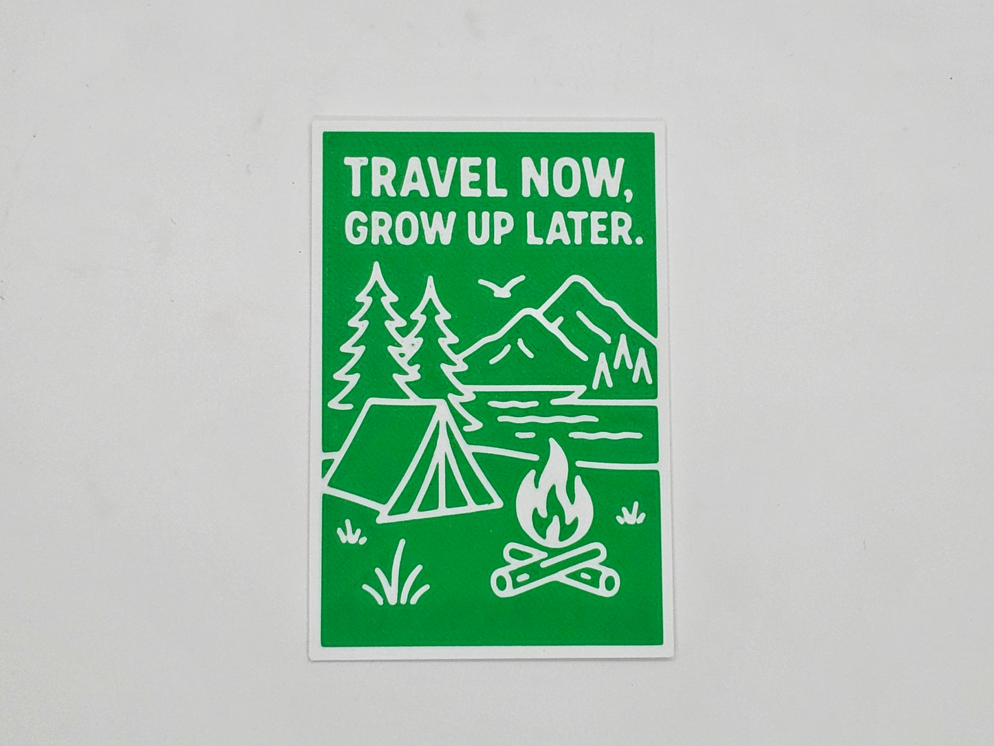 Green and white Travel Now Grow Up Later camping magnet
