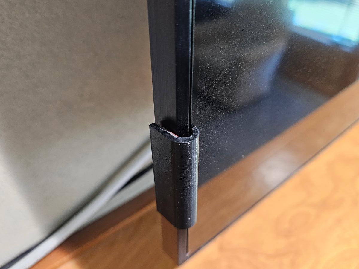 Black TV screen retention clip showing how it fits around the television screen edge